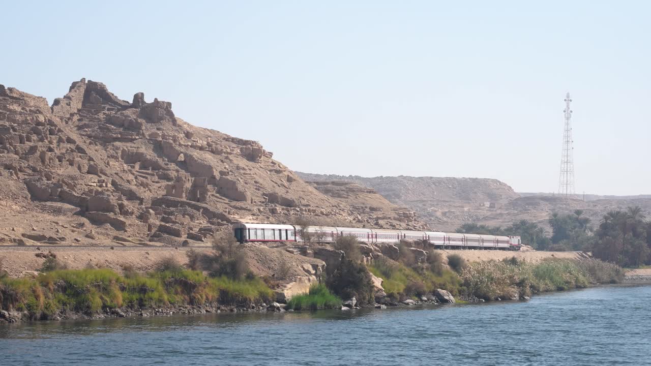 Train accelerating along the bank of the NIle River in Egypt