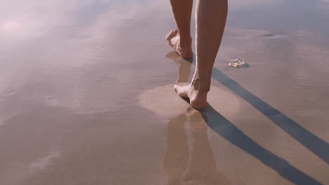 Cerrar-Los-Pies-De-Una-Mujer-Caminando-Descalzo-En-La-Playa-Al-Atardecer-Dejando-Huellas-En-La-Arena-Turista-Femenina-En-Vacaciones-De-Verano