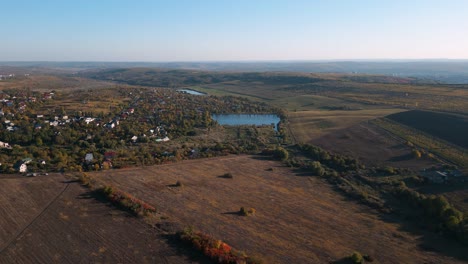 vuelo aéreo de drones en otoño de codru, chisinau, moldavia en 2022 - campos coloridos y árboles con un lago de pesca en el centro - lugares románticos para viajar en las regiones vinícolas de moldavia