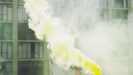 Fashionable-young-woman-on-urban-rooftop-using-a-smoke-grenade