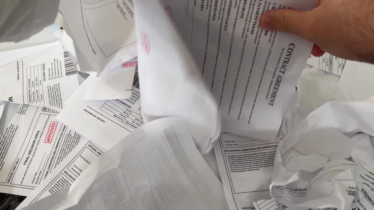 Hands Crumpling Printed Documents in Frustration Over Paperwork