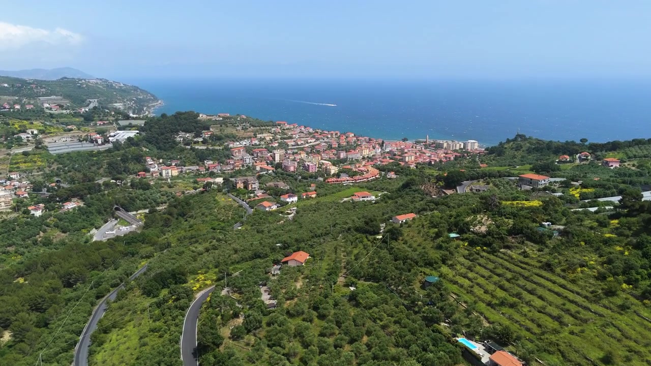 Ripresa introduttiva con drone che si avvicina alla città di Arma di Taggia, in una giornata di sole in Italia.
