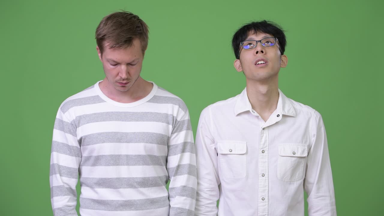 두 명의 젊은 다민족 사업가들이 서로 반대 방향을 바라보고 있습니다.