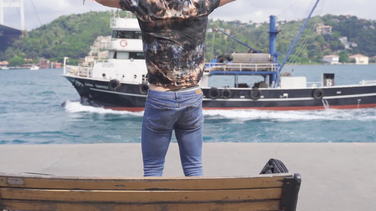 hombre alegre trabajando en su tabla contra el mar en la ciudad.