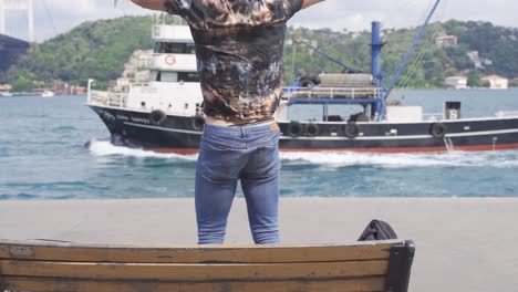 hombre alegre trabajando en su tabla contra el mar en la ciudad.