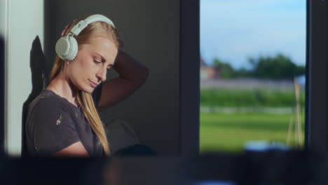 Pensive-Woman-Listening-to-a-Podcast-on-Wireless-Headphones