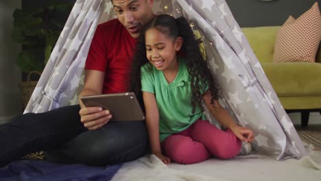 Happy-biracial-father-and-daughter-using-tablet-together