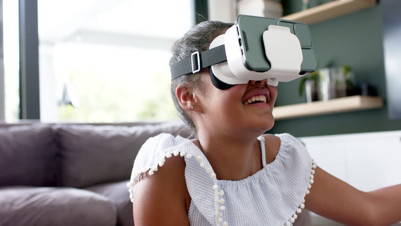 Happy african american girl in vr headsets using virtual interface at home, copy space, slow motion