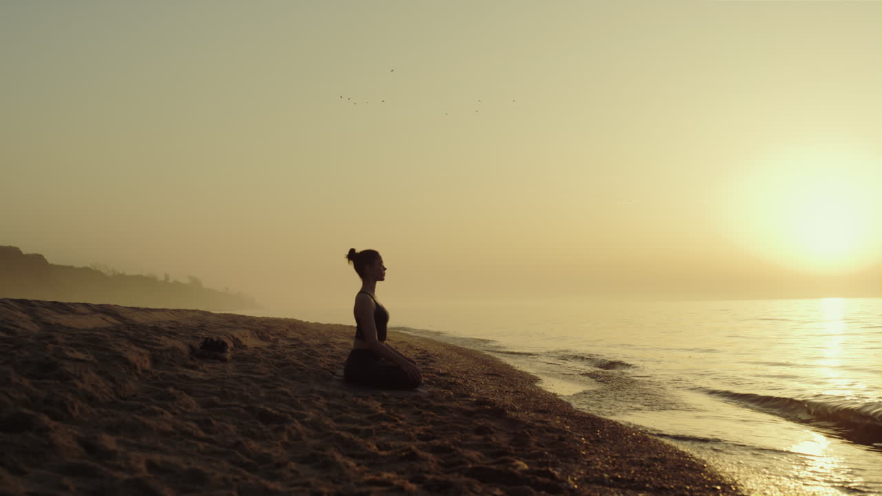 una mujer de yoga practicando meditación en una playa de arena. una mujer relajándose en la naturaleza.