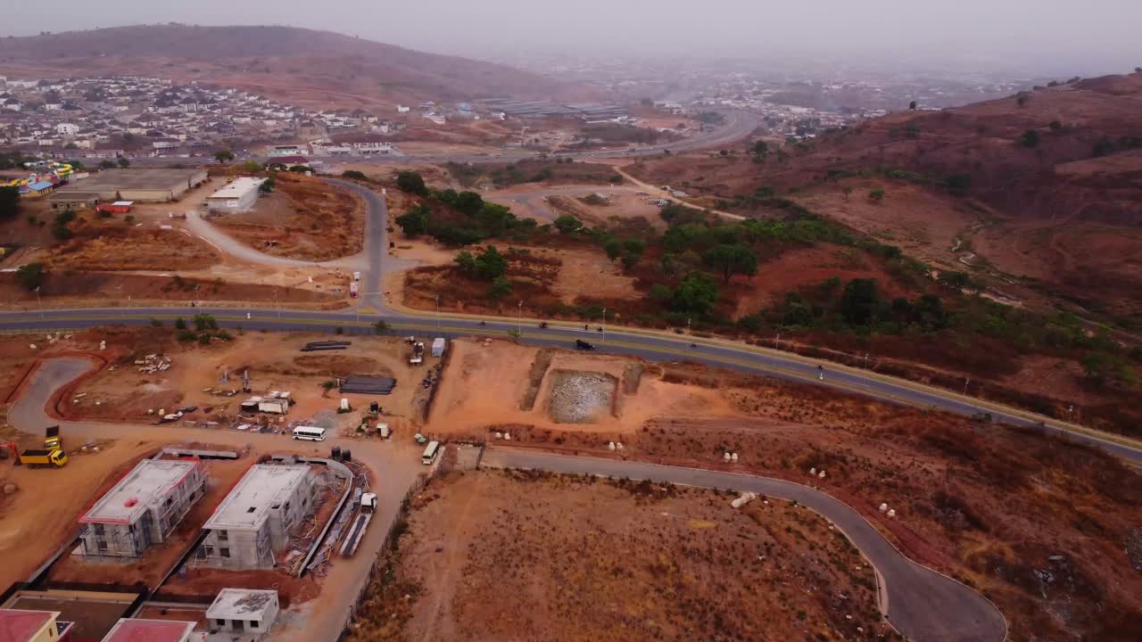 Beautiful aerial of a long road in the Nigerian countryside with traffic driving peacefully on the street