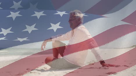 animation of smiling senior caucasian man sitting on beach over flag of united states of america