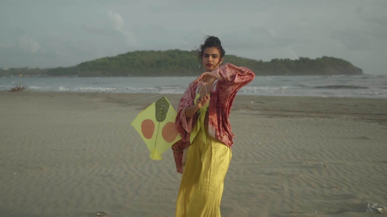 A stunning, captivating Asian model, adorned in an elegant yellow and red ensemble, gracefully stands on a picturesque beach
