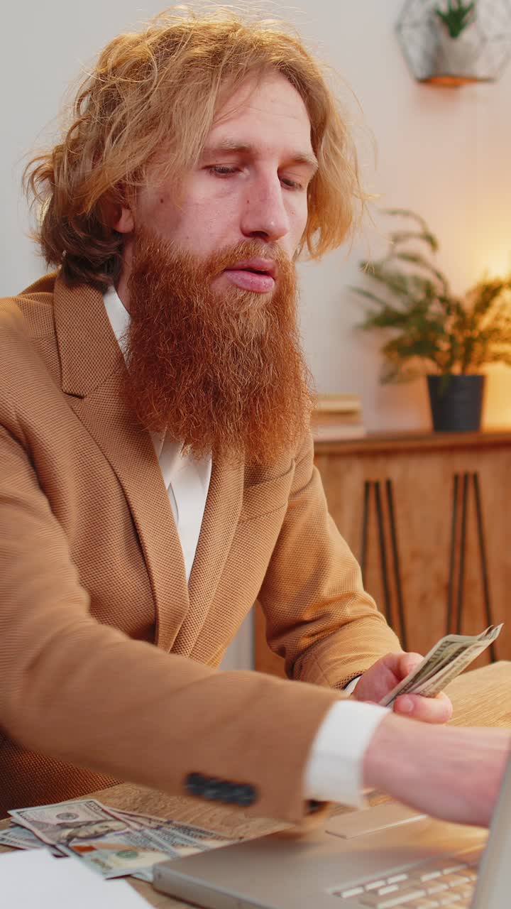 empresario rico exitoso contando dinero en efectivo calcula dividendos y usando portátil en la oficina en casa