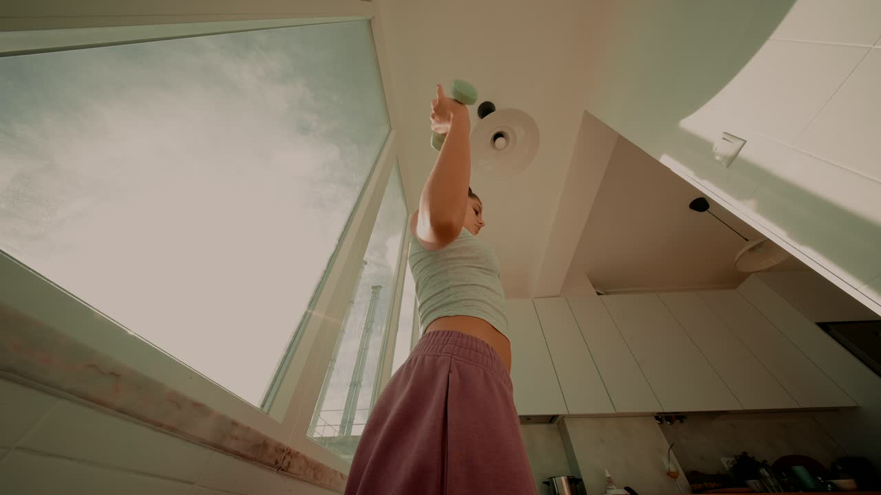 Woman exercising indoors with a dumbbell