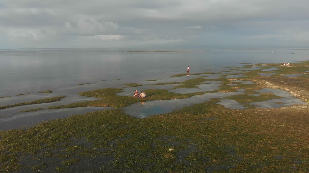 Vista aérea de mulher e barco de pesca tradicional ao nascer do sol na Praia de Paliton, Siquijor, Filipinas