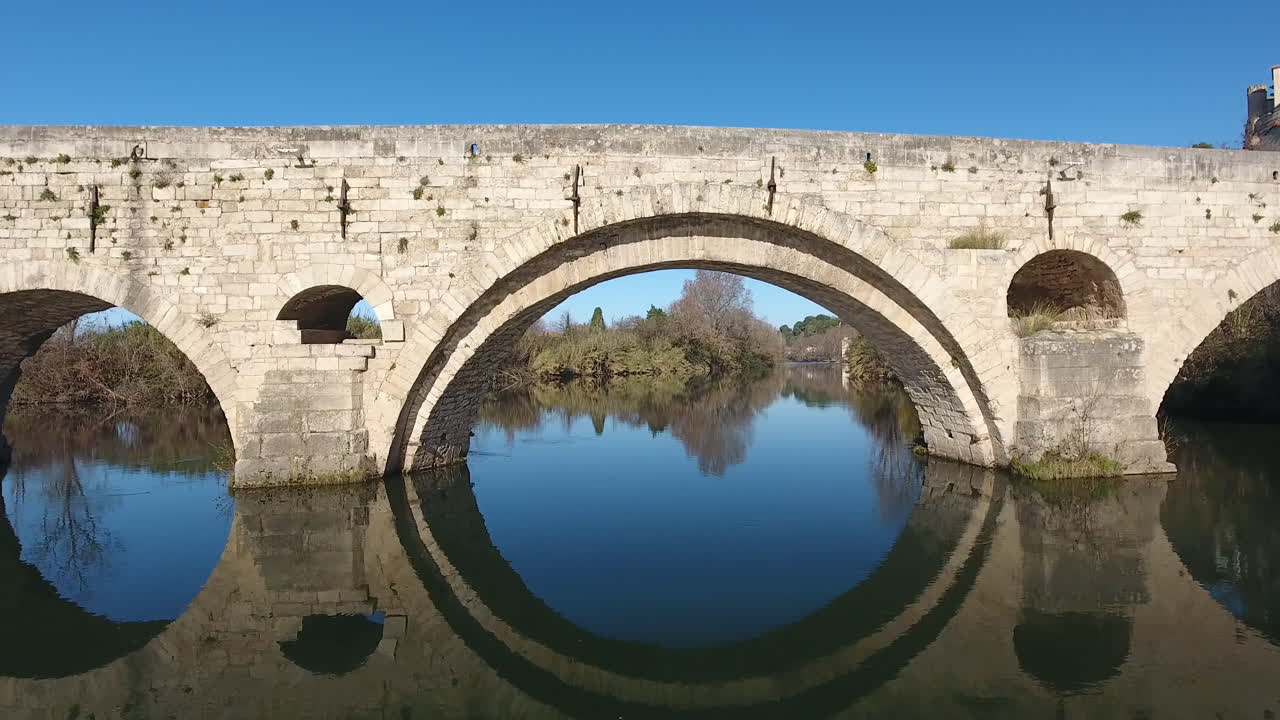 volando a través de un arco del puente vieux orbe del río en beziers viejo puente