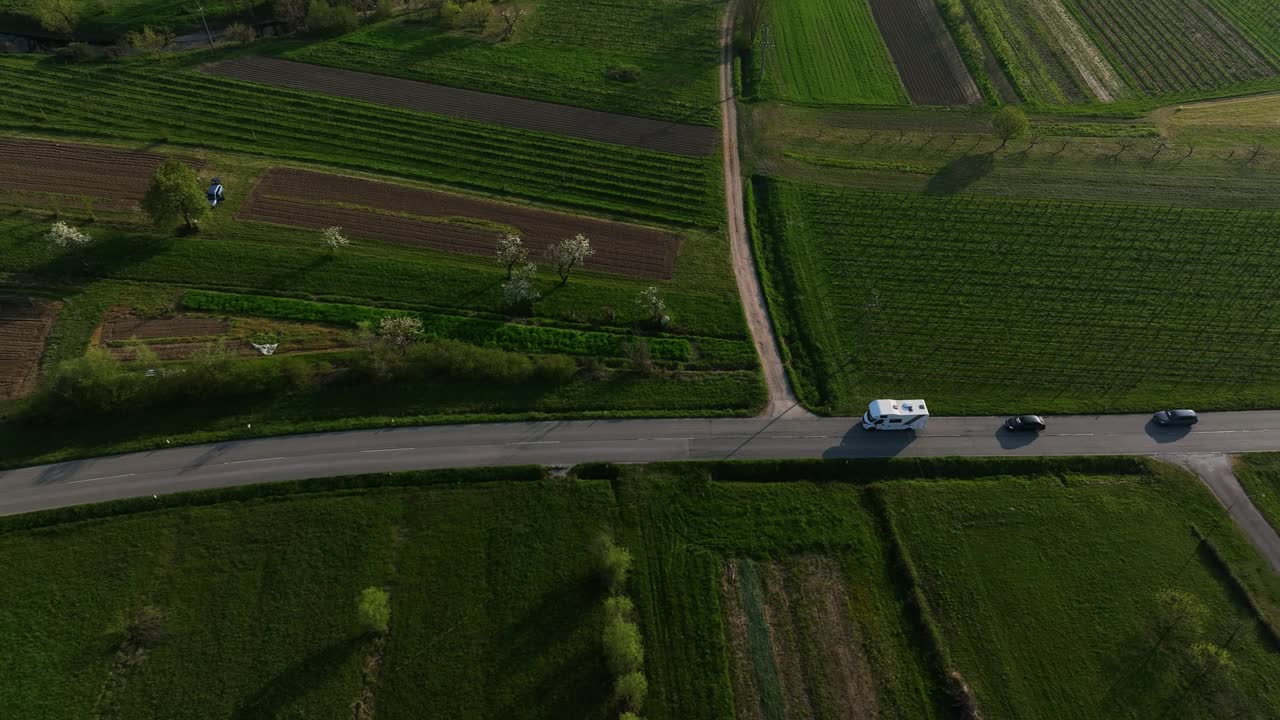 Tracking drone shot of white van on a road during the day in Vipava Valley, Slovenia