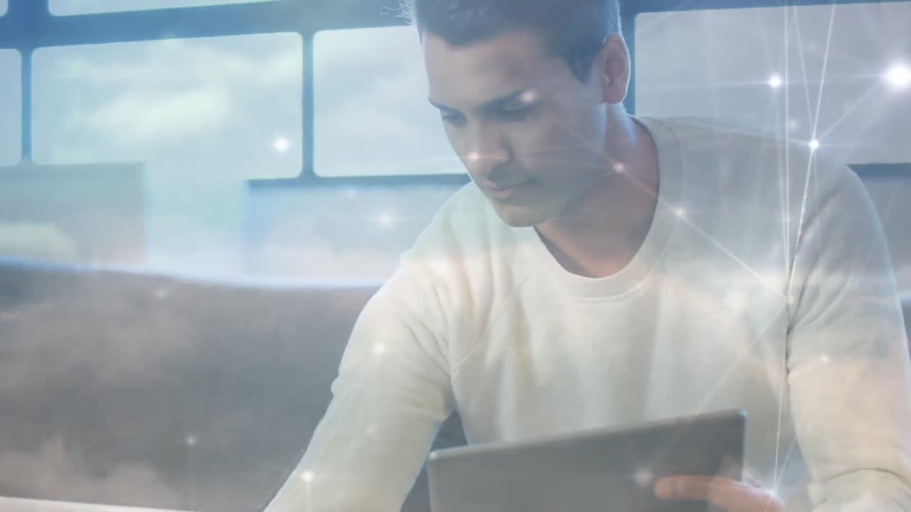 Animation of networks of connections over caucasian businessman using laptop and tablet