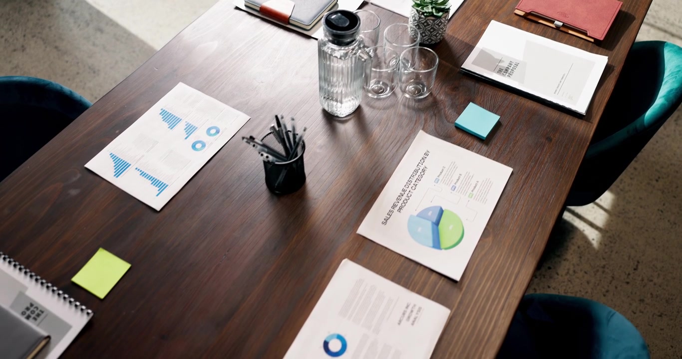 High Angle View of Business Meeting Table with Documents and Charts