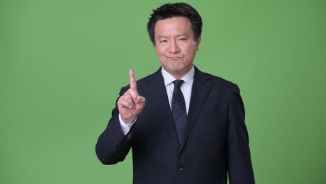 녹색 배경에 성숙한 일본 사업가