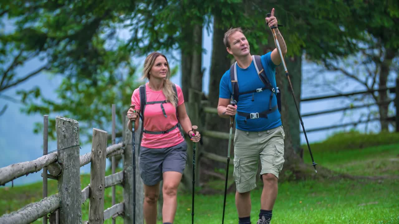 Walking wanderer couple with hiking gear and backpack exploring surroundings