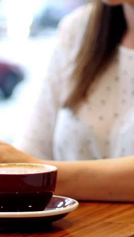 mujer de negocios usando una tableta digital en una cafetería