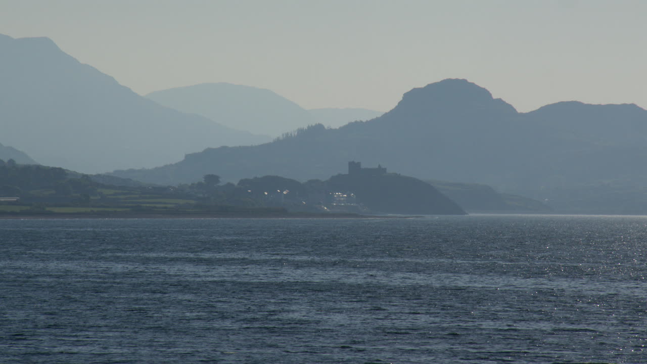 long shot of Eryri National Park Snowdonia with Castle Harlech at Hafan y Môr on Pen-y-chain, Pwllheli