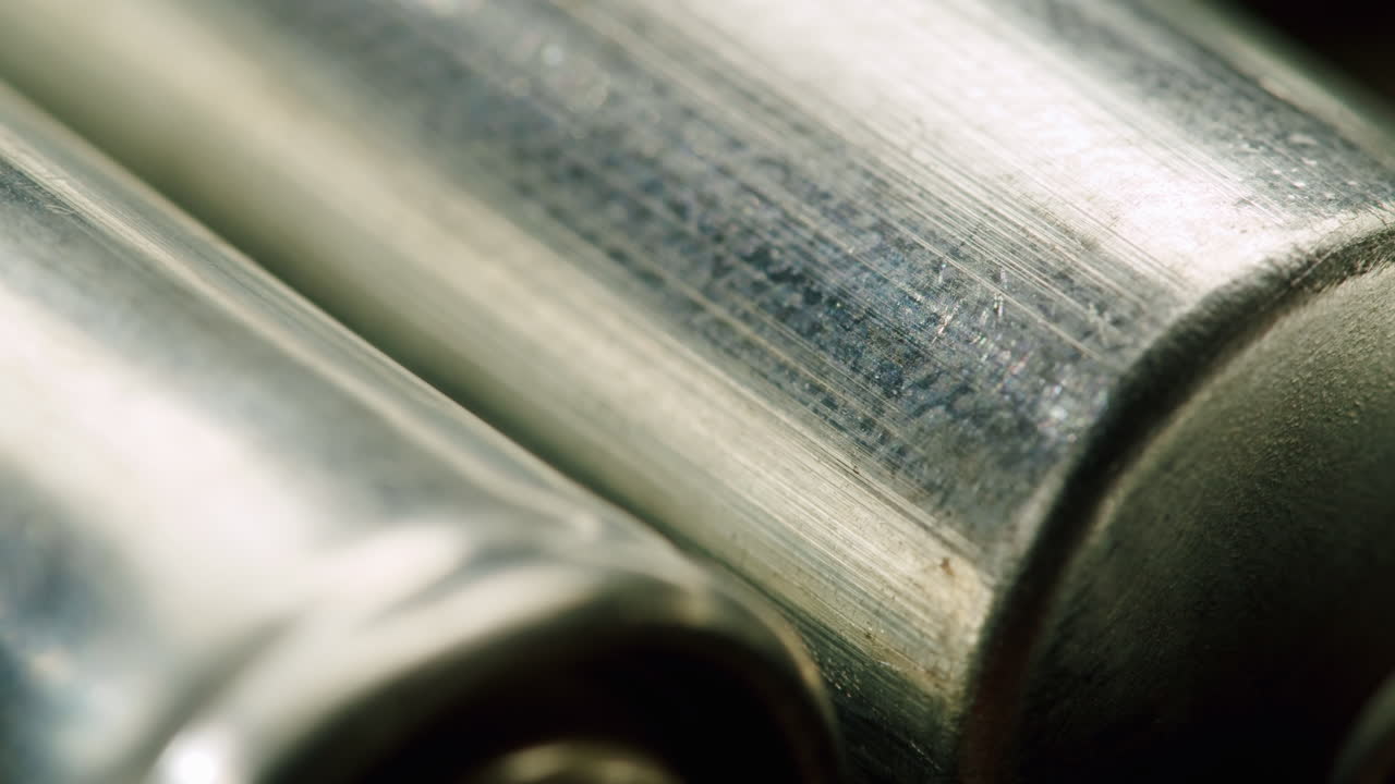 Silver batteries AA and AAA on black background close-up. Double-A battery is a standard size single cell cylindrical dry battery. Batteries are common in portable electronic devices. An AA battery is composed of a single electrochemical cell that may be either a primary battery or a rechargeable ba