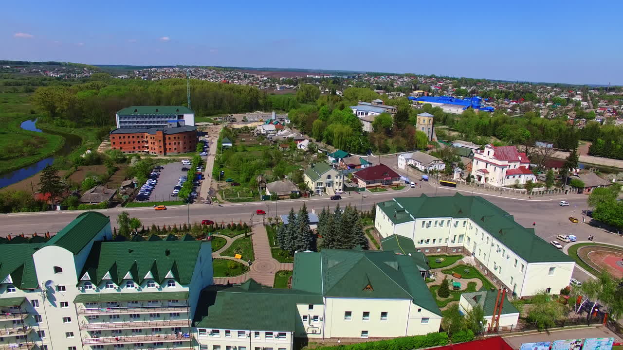 Colorful architecture of the provincial city on sunny summer day. Town with lush greenery from top view.