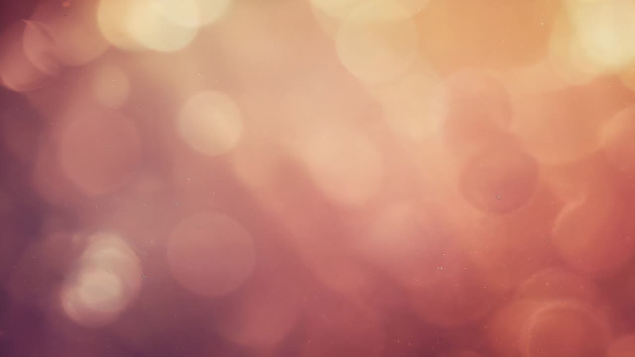 Shifting bokeh field pulsing as frames starting shimmer in warm studio backdrop with flare points