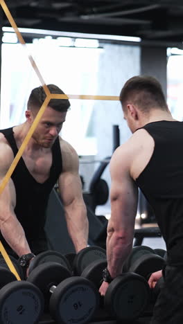 muscular man doing exercises with dumbbells