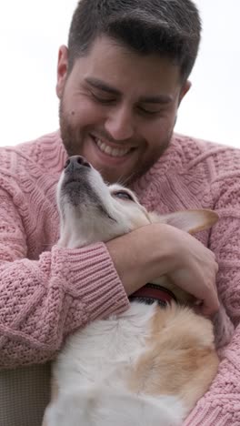 man hugging and stroking his dog while enjoying the day outdoors in the park.