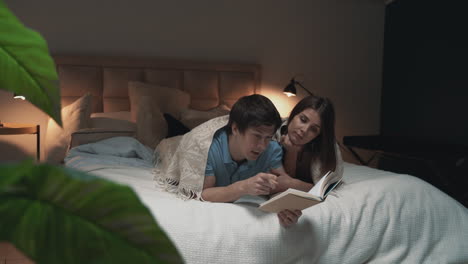 Pareja-Joven-Leyendo,-Cubierta-Con-Una-Manta-1