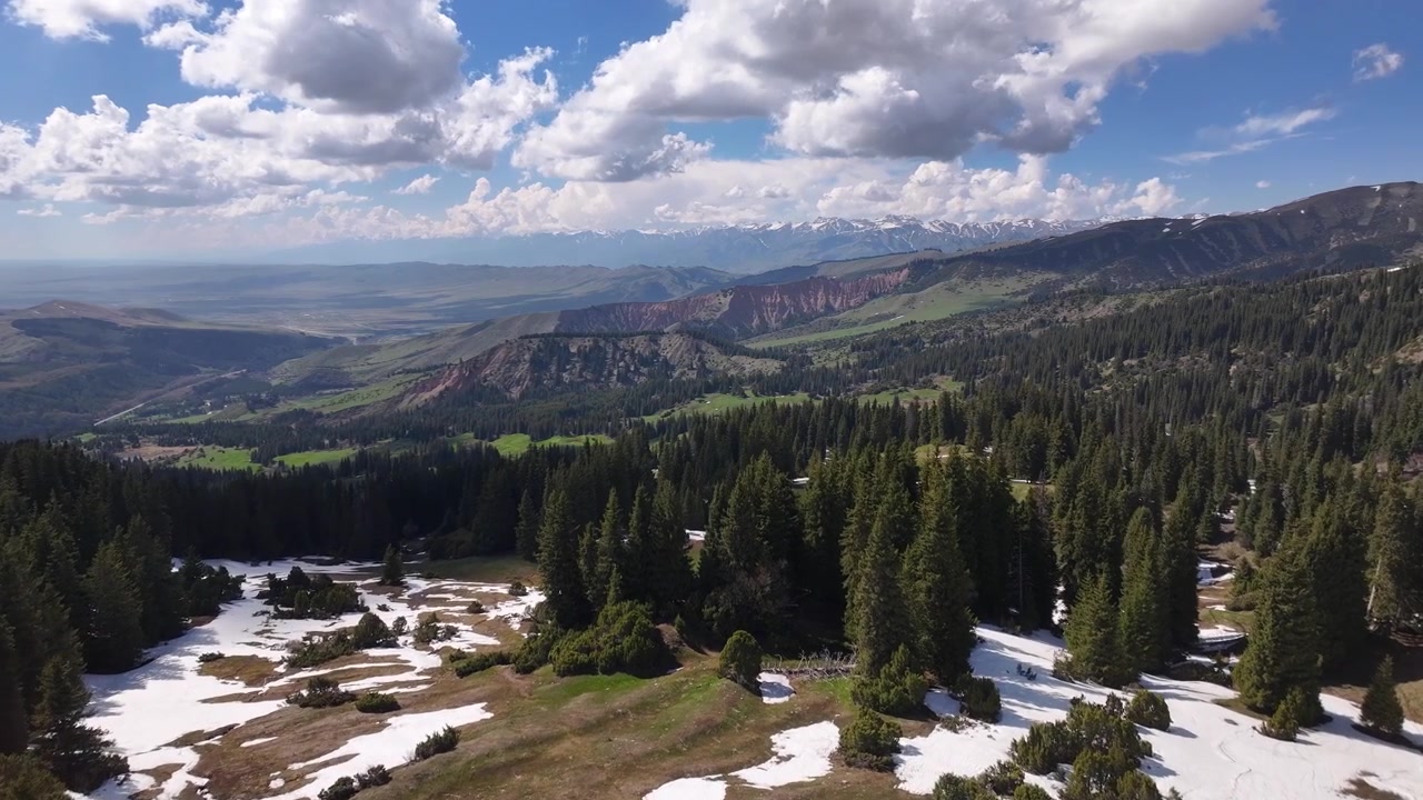 Flygfoto över Jyrgalandalen med snöfläckar, granskog och bergspanorama, Kirgizistan.