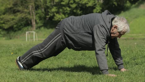 Un-Anciano-Activo-Hace-Ejercicios-Físicos-De-Flexiones-En-El-Patio-Deportivo