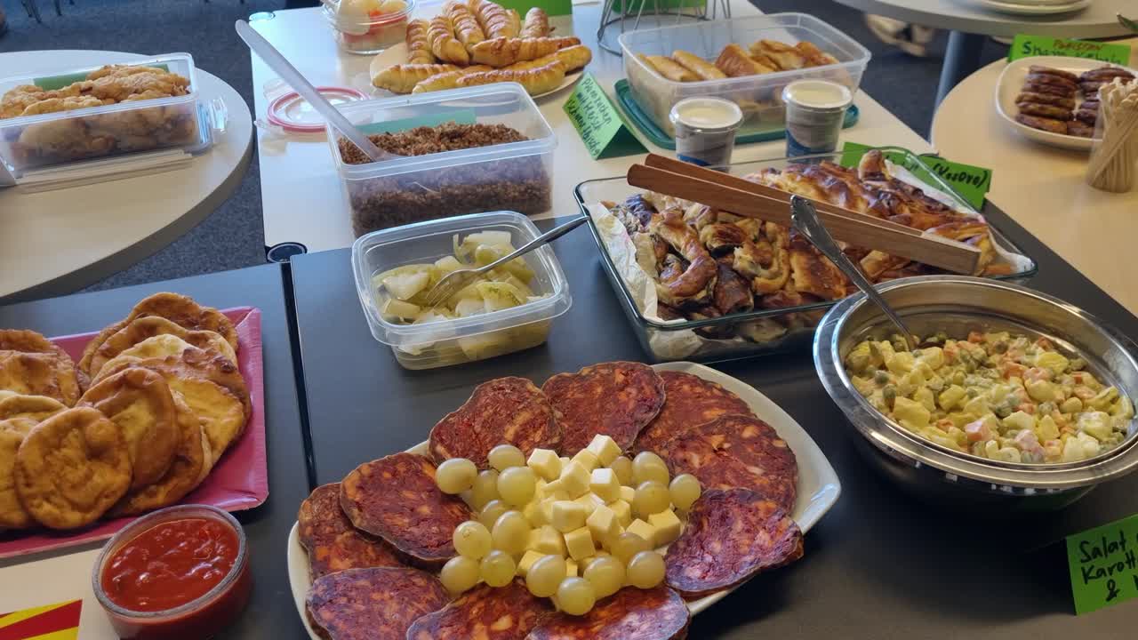 Cibo internazionale fatto in casa esposto su un tavolo da buffet, tra cui kulen slavonski, insalata fresca e burek, tra le altre specialità tradizionali, che mettono in mostra la cucina culturale e l'autentica cucina casalinga