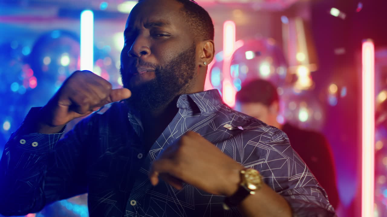 African american man making movements in club. Afro guy winking at party