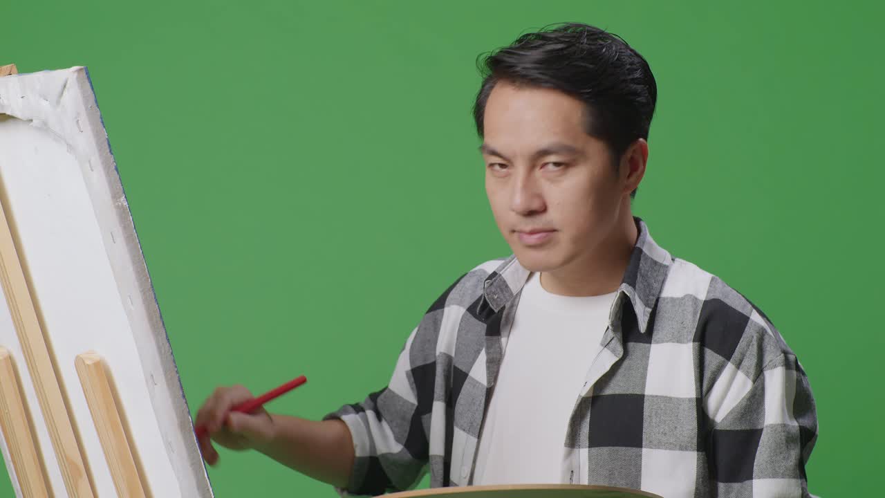 녹색 스크린에 그림을 그리는 장비를 가진 예술가