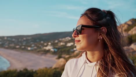 beautiful profile shot of pretty lady wearing sunglasses enjoying seascape