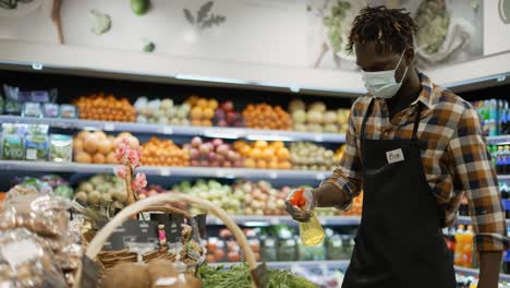 african american worker refreshing and arranging greens in the store