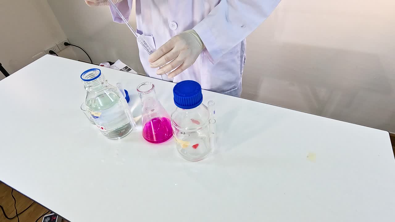 A scientist conducts a chemical experiment with potassium permanganate, demonstrating color change reactions under controlled conditions