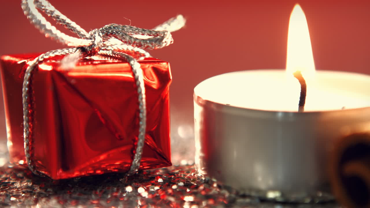 vista de la vela ardiendo junto al pequeño regalo de navidad