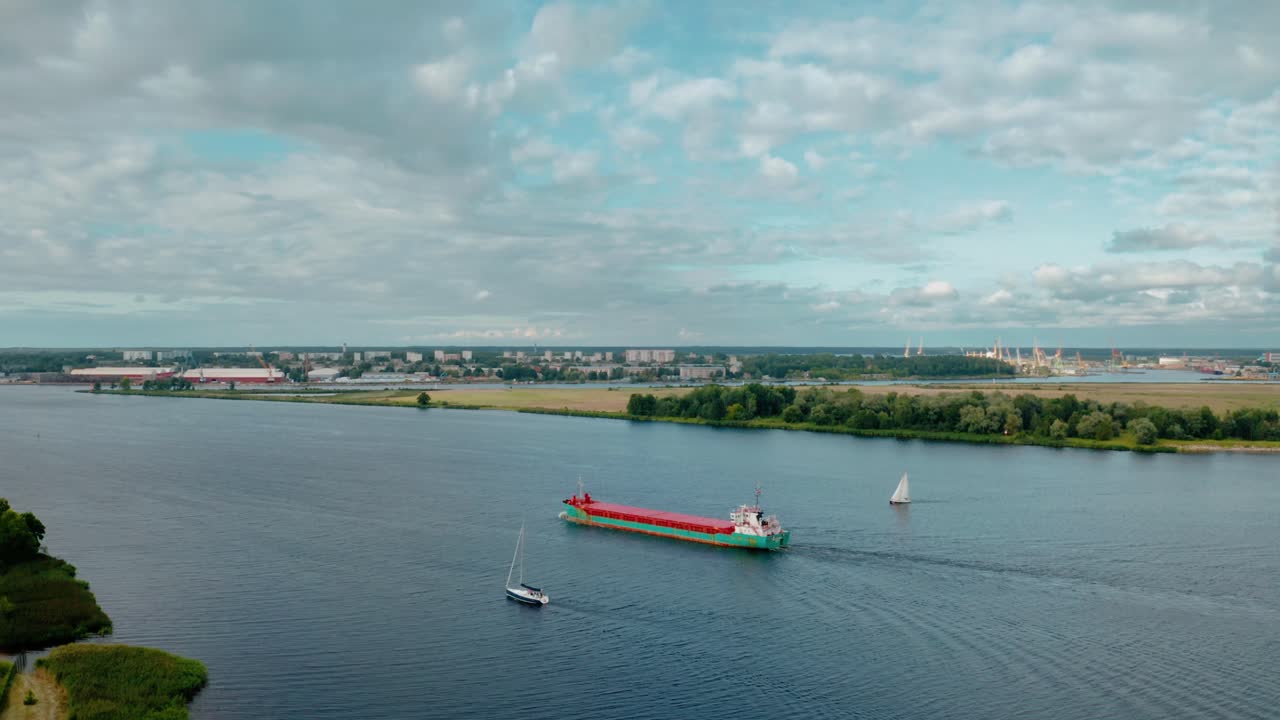 강 통로 를 통과 하여 개방 된 물 으로 항해 하는 화물선 의 공중 사진