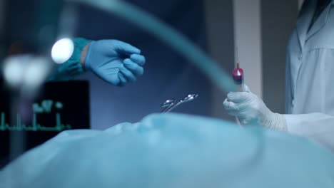 surgeon team hands. surgeon operating. gloved hands giving blood syringe