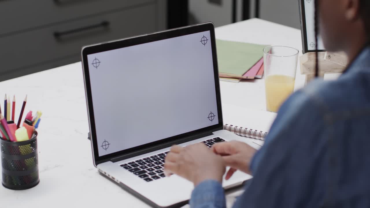 African american teenage girl studying at home using laptop with copy space on screen in slow motion