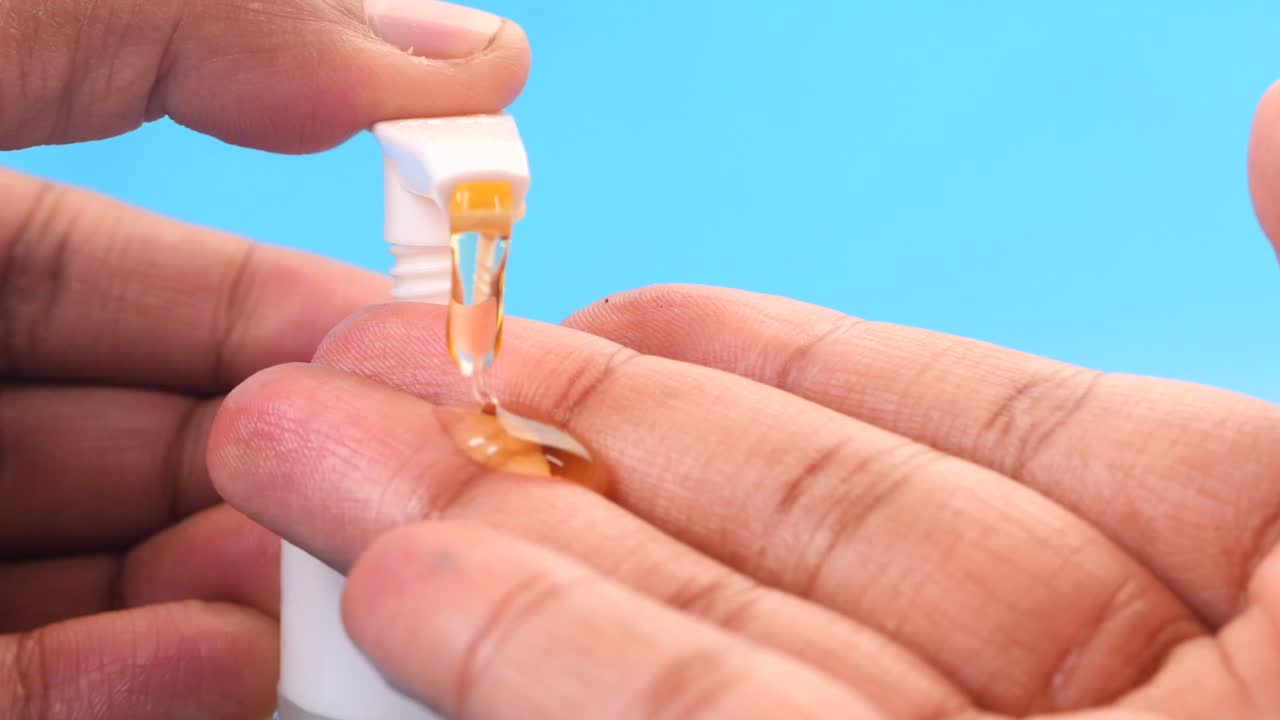 손을 기 위해 액체 비누 병을 사용하는 사람