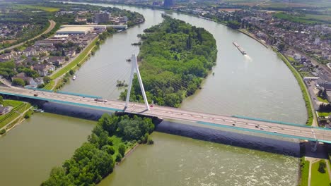a breathtaking aerial view of the neuwied rhine bridge, capturing busy road traffic as trucks and cars cross ovver the river. a key european trade corridor, framed by lush nature and urban landscape.
