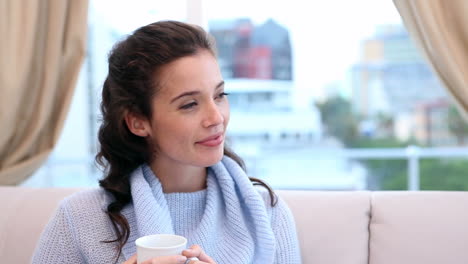 Happy-brunette-relaxing-on-the-couch