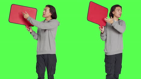 young man holds speech bubble in studio