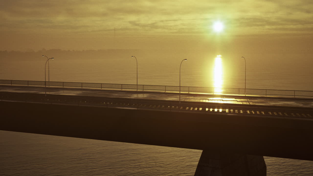 Sunrise casts golden hues over quiet bridge and calm water